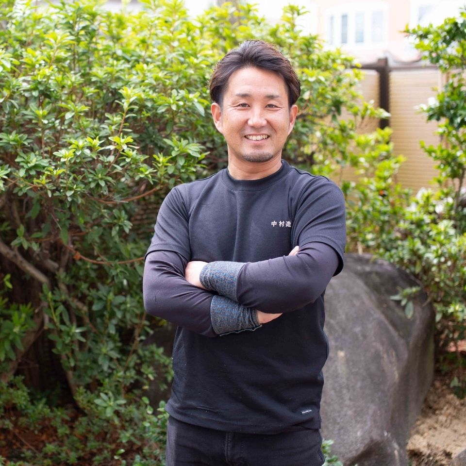 庭師が庭を背景に立っているイメージ写真