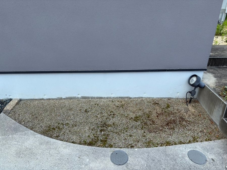 植栽前の建物前スペース。砂利が敷かれ、活用方法に悩まれていた施工前の写真。